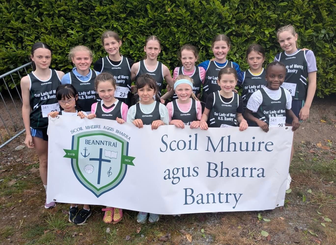 School athletics team holding the Scoil Mhuire agus Bharra banner
