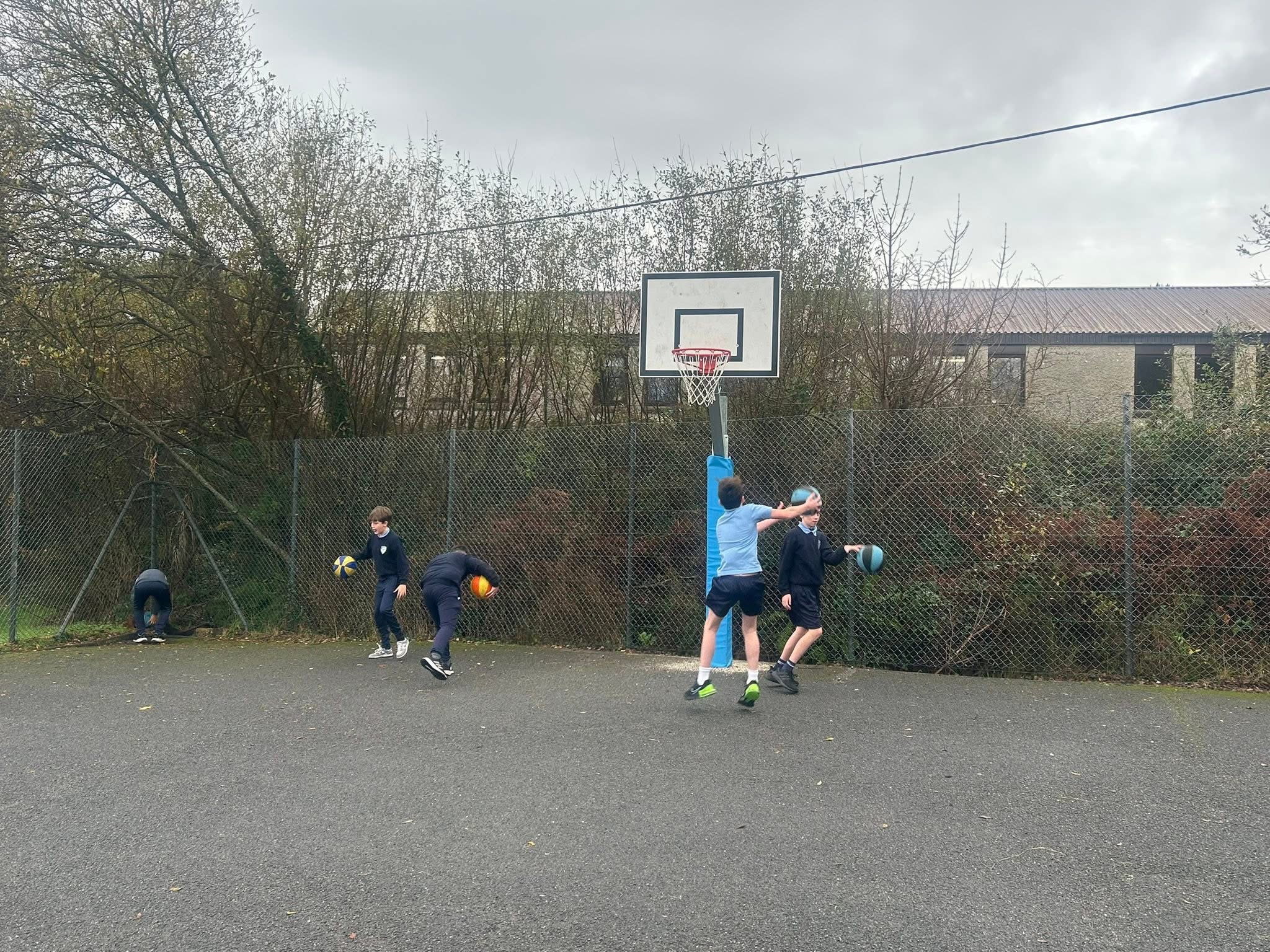 Pupils practising basketball on the school court